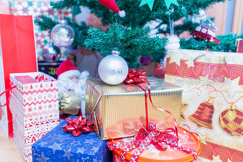 圣诞树下装饰的礼品盒。新年礼物，圣诞前夜圣诞树下不同的礼盒，圣诞节庆祝活动，家居装饰室内拍摄。有选择性的重点。