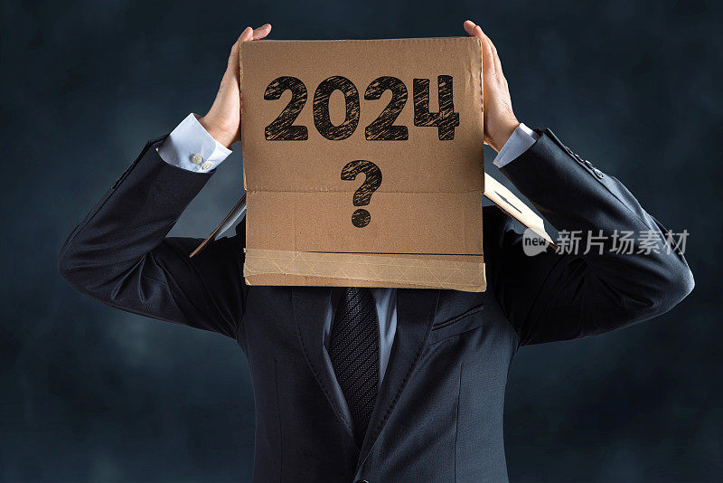 商人头上戴着一个纸板箱。纸板箱上写着2024年，还有一个问号