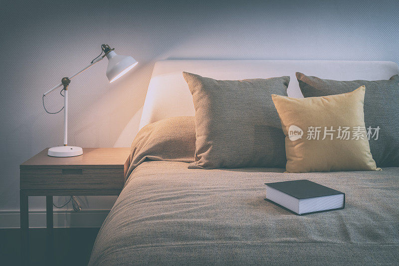 舒适的卧室内部与书和阅读灯