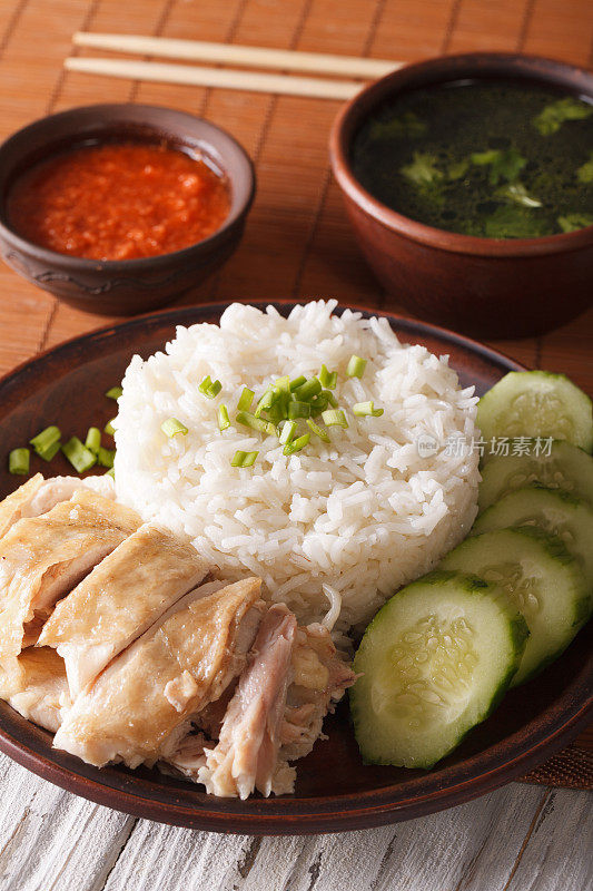 海南鸡饭特写，辣椒酱和肉汤。垂直
