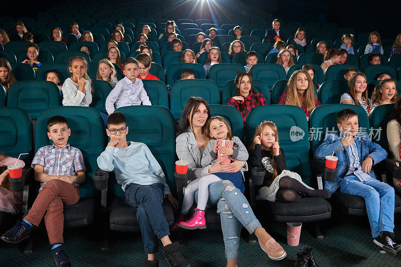 孩子们和父母一起在电影院看电影