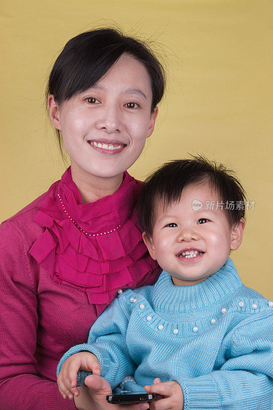 亚洲母亲和婴儿抱着移动电话