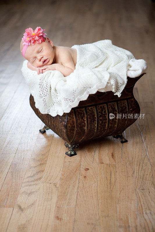 熟睡中的新生女婴带着发带和蝴蝶结