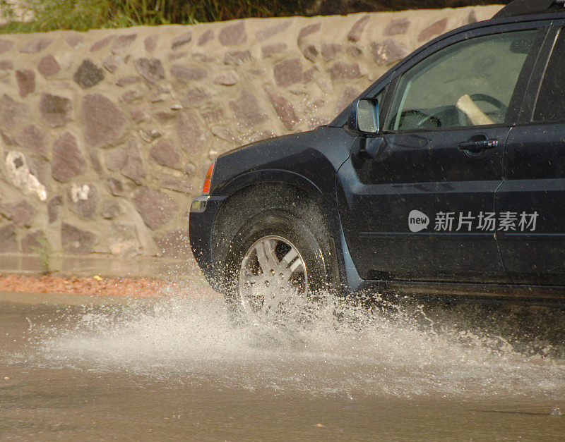 汽车轮胎在雨中溅起水花