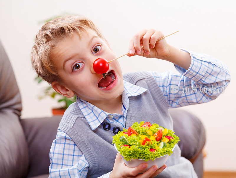 顽皮的男孩与红番茄的鼻子显示小丑