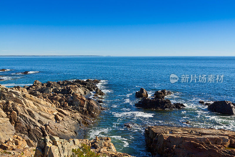 缅因州Ogunquit的岩石和海洋冲浪。蓝色的天空。