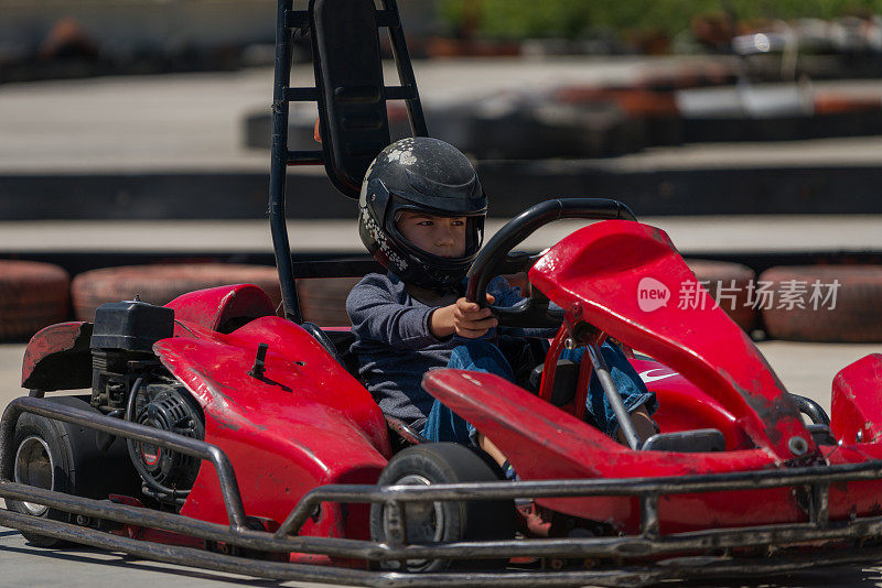 一个小男孩在跑道上驾驶卡丁车