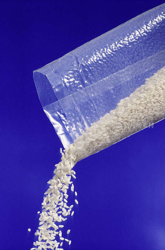 白色生米从包装上掉落，蓝色背景