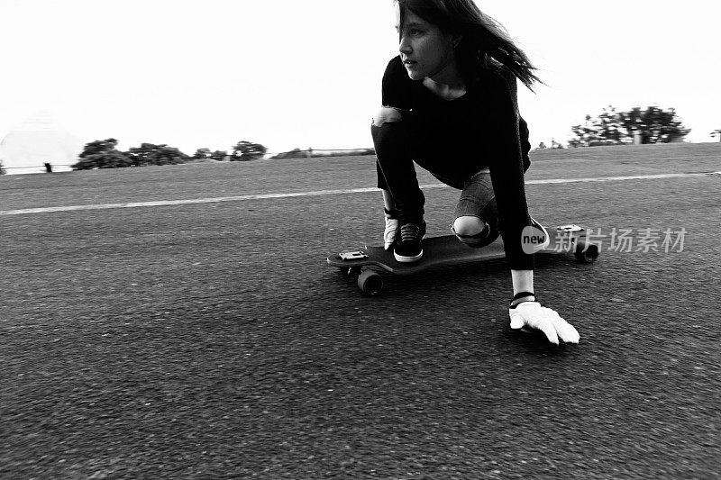 年轻女子在柏油路面滑冰