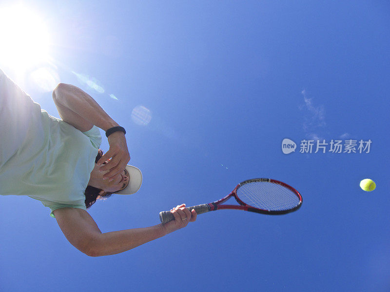 女子用球拍击打网球左手太阳耀斑
