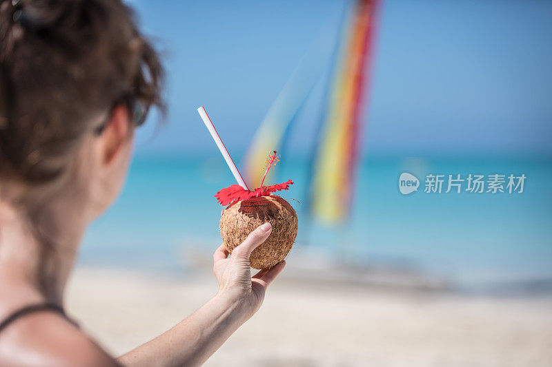 女人放松在海滩与热带饮料，古巴