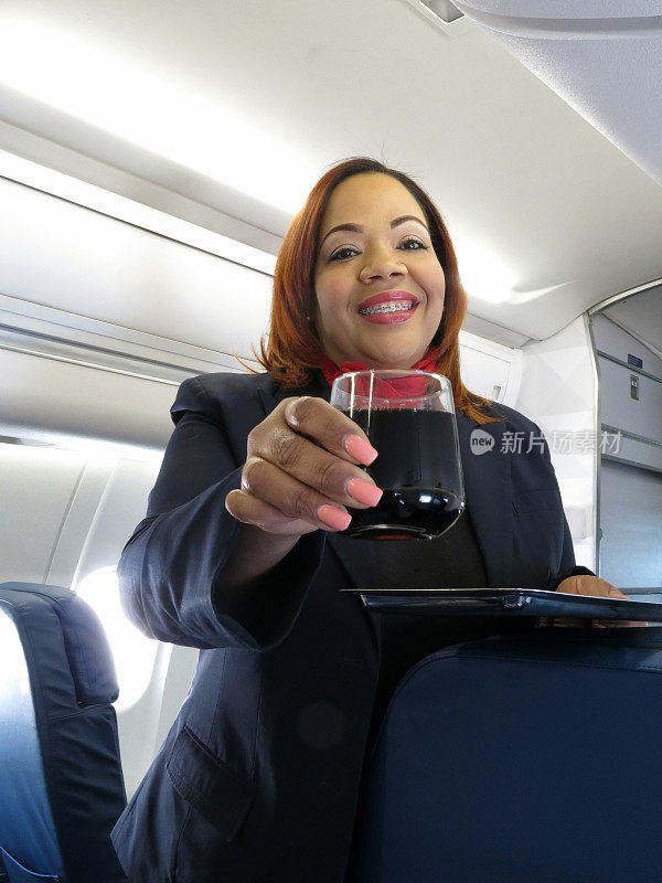 女乘务员向航空乘客提供饮料