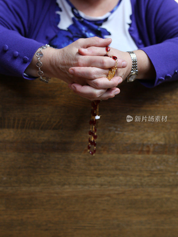 老妇人跪在天主教教堂的皮尤祈祷