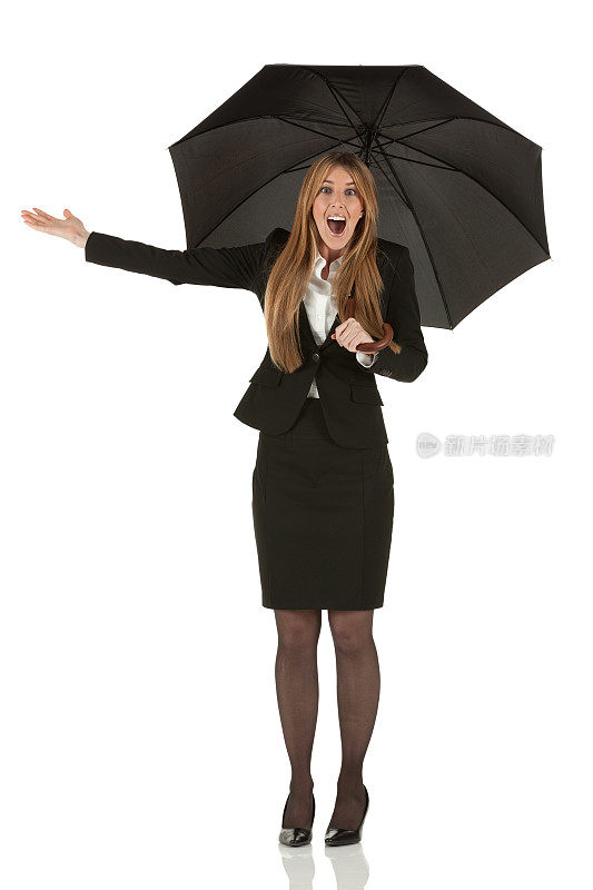 兴奋的女商人站在伞下