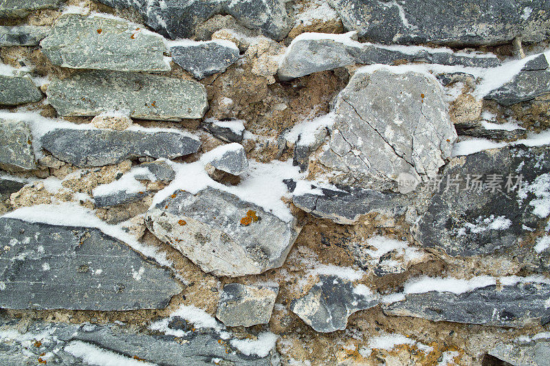 冬天用石头砌成的墙，被雪覆盖