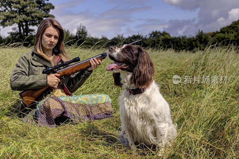 年轻的女孩带着枪和狗准备去打猎