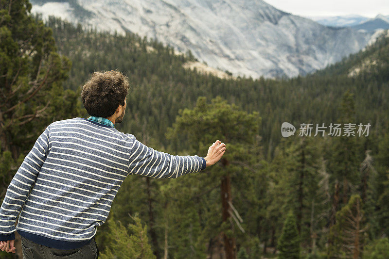 这位年轻的游客，在蒂奥加山口公路上用摄像机拍摄优胜美地国家公园