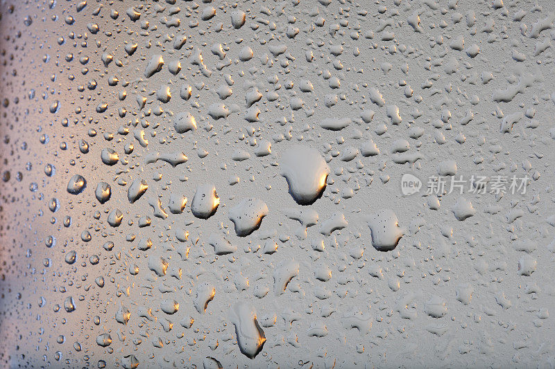 冰冷的玻璃覆盖着水珠凝结冷饮水珠灰色的背景雨点纹理近