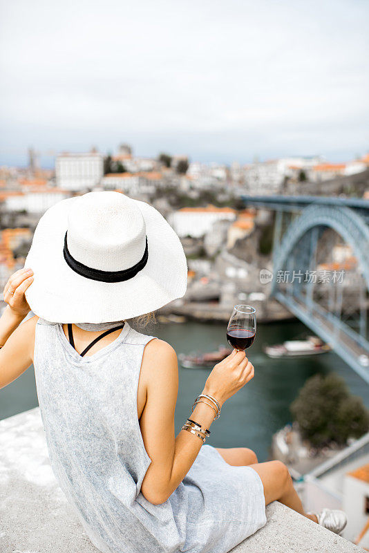 在葡萄牙，拿着一杯波尔图葡萄酒的女人