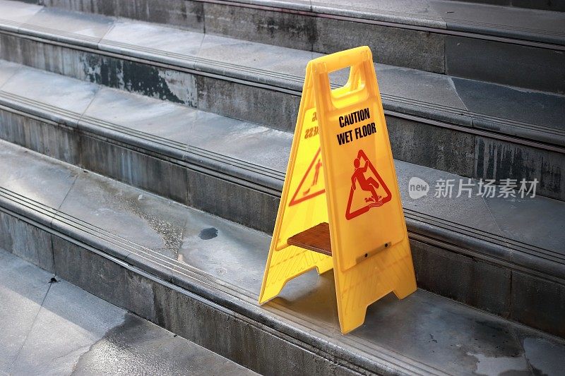 室外城市楼梯黄色警告湿地板标志。