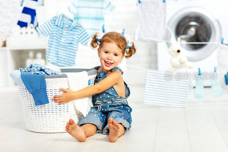 孩子开心快乐的小女孩在洗衣房洗衣服