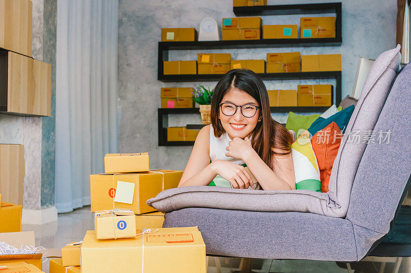 年轻的亚洲青少年业主商业女性在家工作，网上购物，检查订单和准备包装的产品与办公设备，企业家和阿尔法一代的生活方式的概念