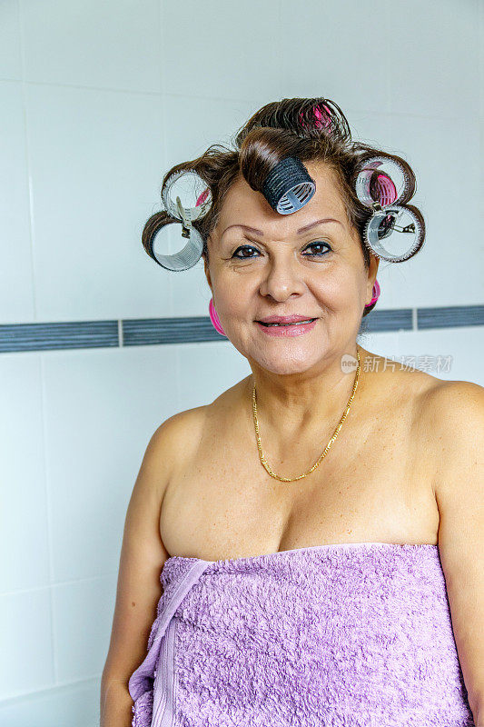 成熟的西班牙女性戴着卷发器