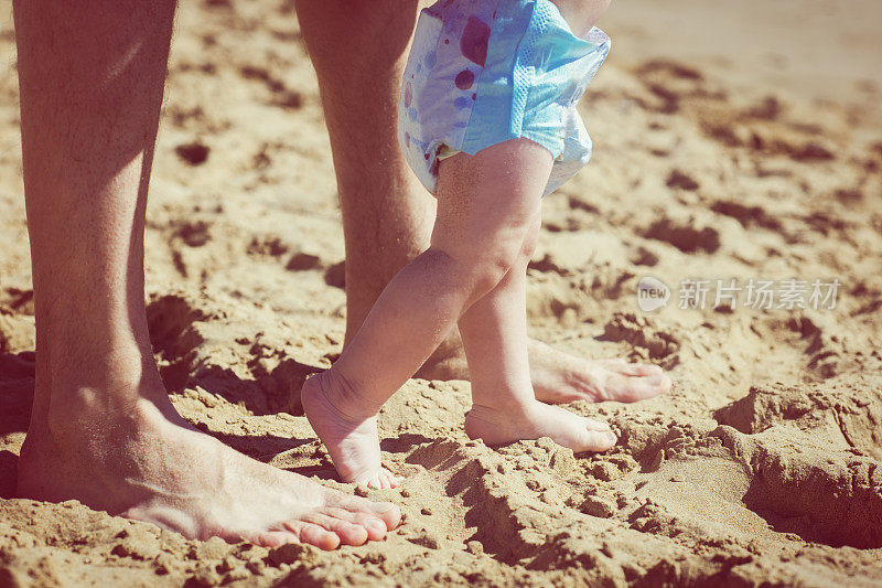 婴儿在海滩上的第一步