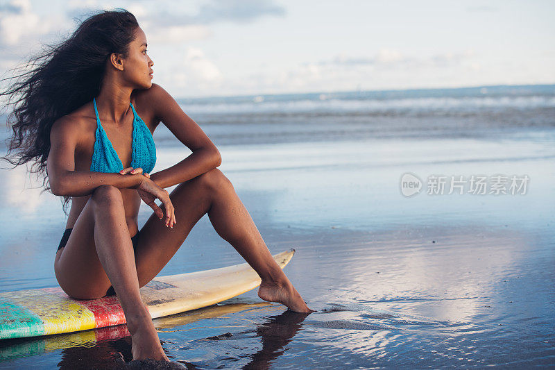 日落时分，海滩上的冲浪女孩