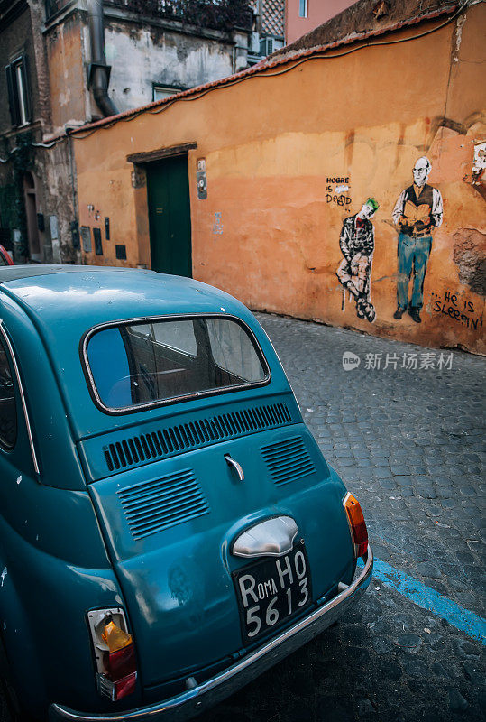 老式的意大利蓝色汽车在鹅卵石街道上
