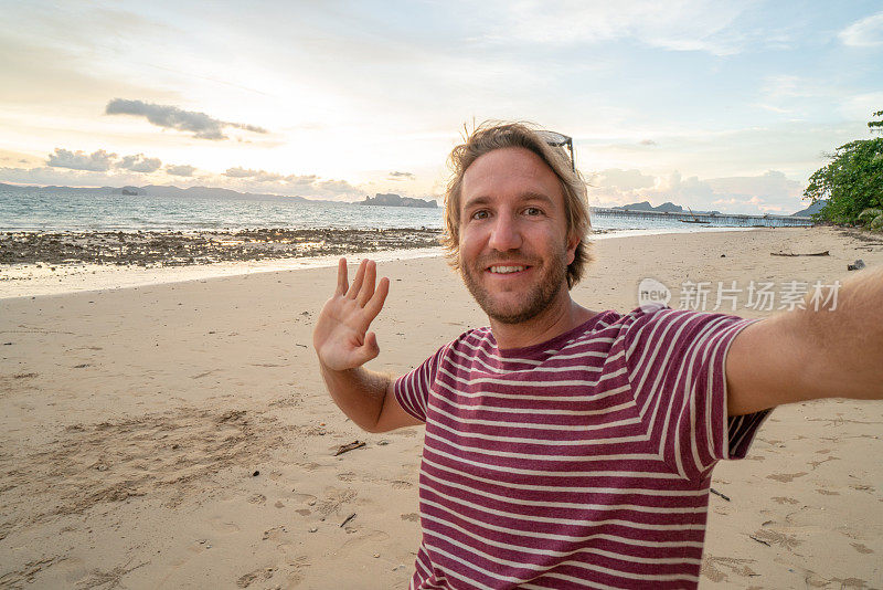 一名年轻人在泰国海滩上自拍。人们旅行豪华度假乐趣和酷的态度概念