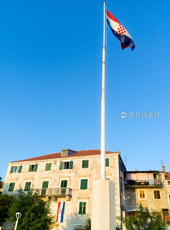 桅杆上挂着克罗地亚国旗，石头建筑