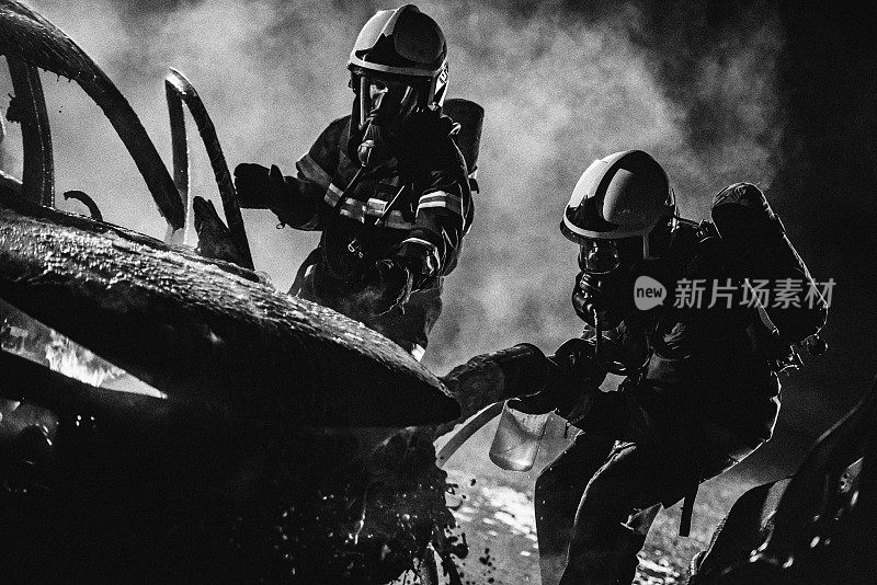 消防队员正在用黑色和白色的泡沫灭火