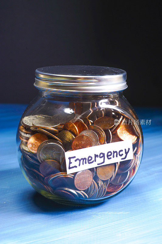 装满硬币的玻璃罐，上面写着“紧急情况”