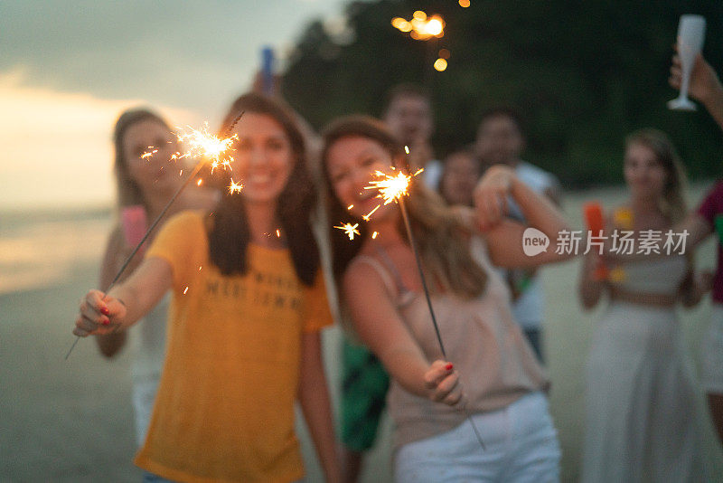 人们在海滩上用闪闪发光的东西庆祝新年