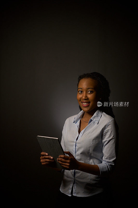 正式商业肖像的成功友好的年轻非洲女商人与一个数字平板电脑