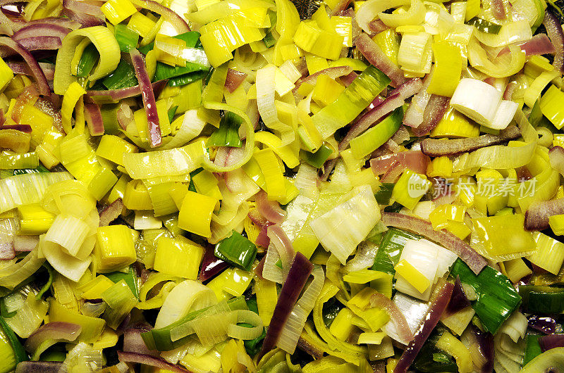 煎锅中切碎的韭菜和洋葱