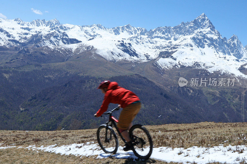 男性山地自行车下山草坡