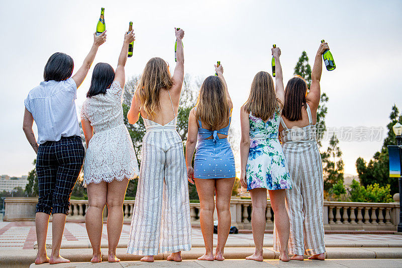 六名女大学生高举香槟酒瓶庆祝毕业