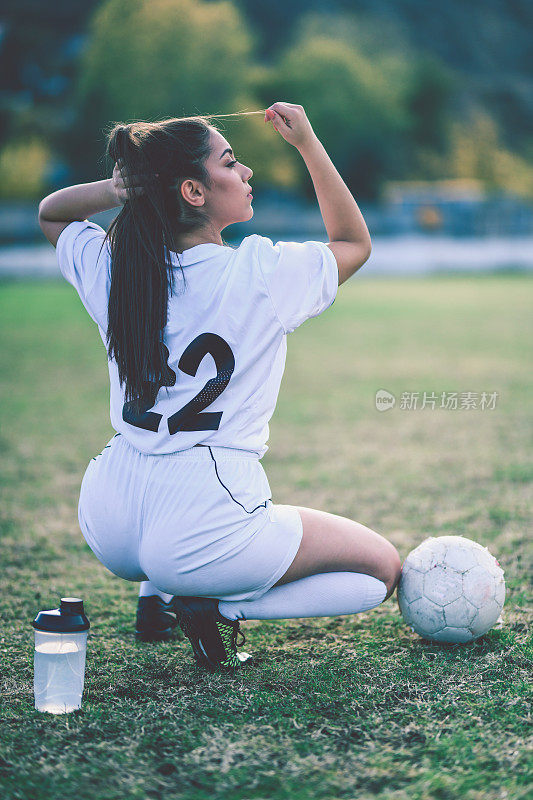 女子足球运动员扎头发开始训练