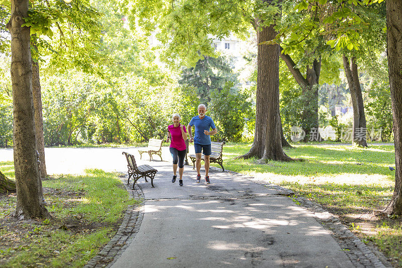 一个老人和他的妻子在公园里晨跑