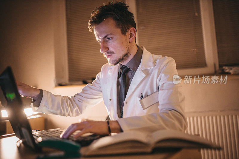 医生在办公室写医疗文件和使用笔记本电脑