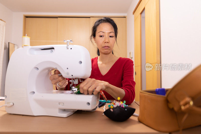 一名日本妇女在家里制作面具