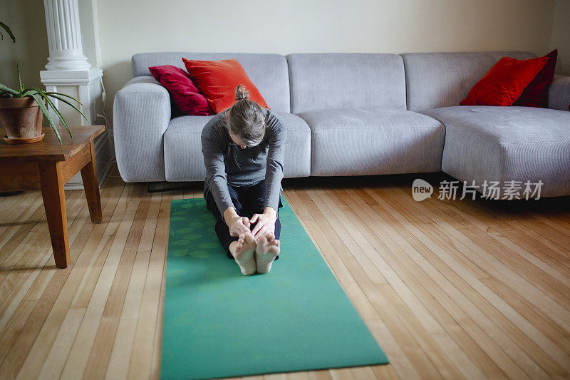 成熟的女人在家做瑜伽