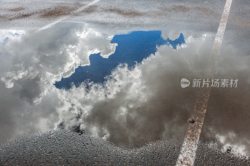 天空与云反映在水坑在停车场，亚利桑那州，美国