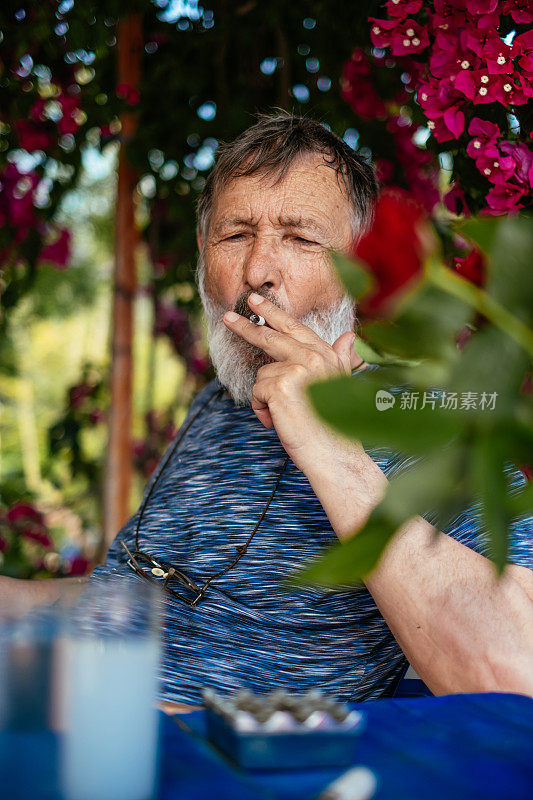 一个老人在喝土耳其拉基茴香酒