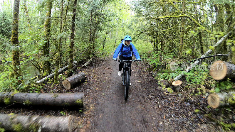 女性山地车沿着森林小径骑电动自行车