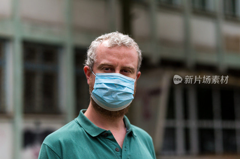 快乐微笑的男人戴着防护面具与城市街道的背景