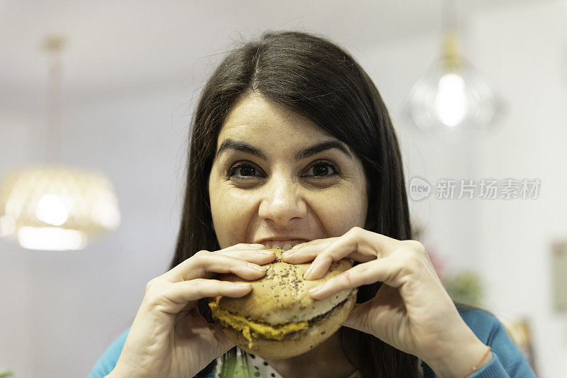 一个年轻白人妇女吃汉堡的肖像