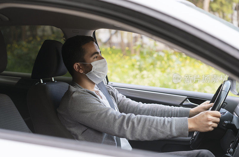 一名男子和他的朋友在城市里戴着防护面具开车